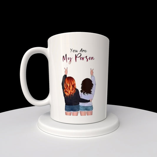 The Kreative Kreationz "Your My Person | Best Friend 20oz Mug" features a sublimated design with an illustration of two people from behind, fingers making peace signs, and the phrase "You Are My Person" above, ensuring lasting quality and sentiment.