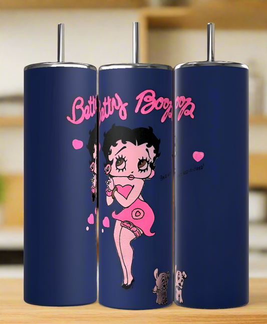 The Kreative Kreationz Betty B Navy 20oz Skinny Tumbler shows Betty Boop in a pink dress with hearts and “Betty Boop” in pink cursive, plus two small dogs by her feet. The reusable tumbler is set against a blurred kitchen background.