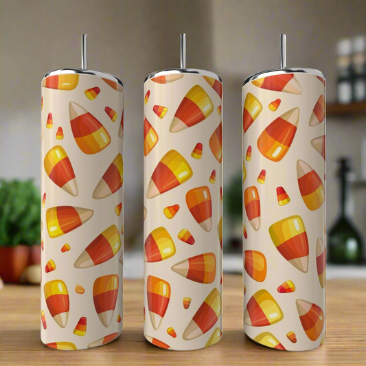 Three Kreative Kreationz Candy Corn 20oz Tumblers are displayed on a kitchen counter, each featuring a vibrant candy corn pattern on cream—perfect Halloween drinkware.
