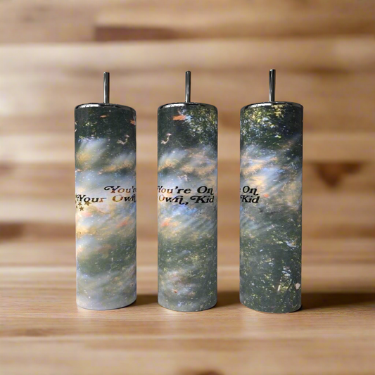 The Your On Your Own Now 20oz Skinny Tumbler by Kreative Kreationz features a captivating space design, offering stylish and reusable stainless steel drinkware for any beverage lover.