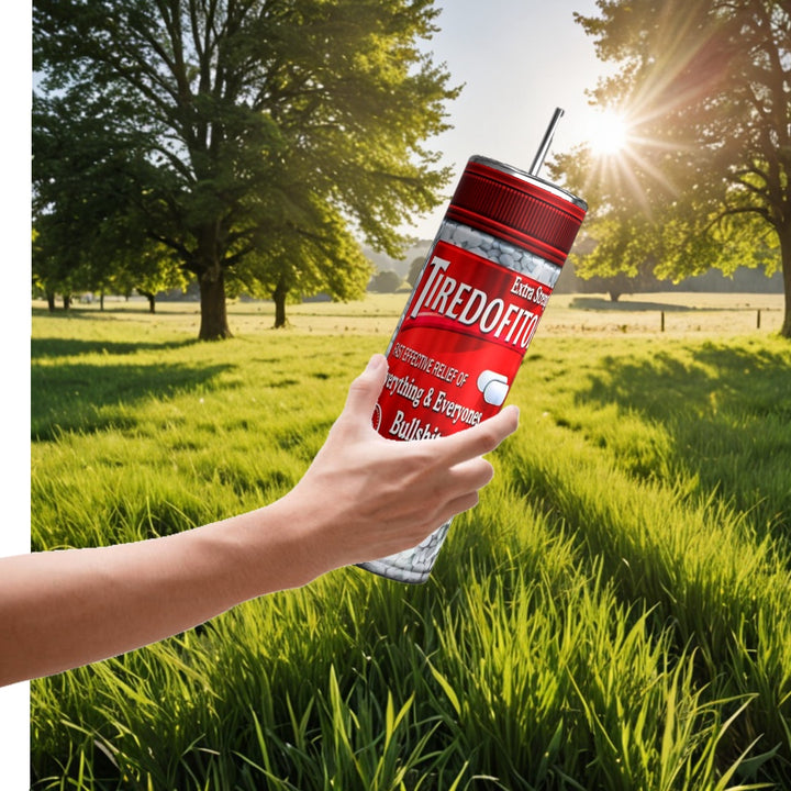 In a serene field with trees, a hand holds a personalized Kreative Kreationz Proceastinex Adult Issues 20oz Skinny Tumbler labeled "Tired of It." Sunlight enhances the outdoor tranquility, while double-wall insulation keeps your drink perfectly tempered.