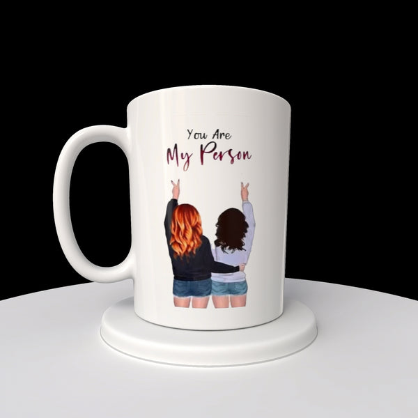 The Kreative Kreationz "Your My Person | Best Friend 20oz Mug" features a sublimated design with an illustration of two people from behind, fingers making peace signs, and the phrase "You Are My Person" above, ensuring lasting quality and sentiment.