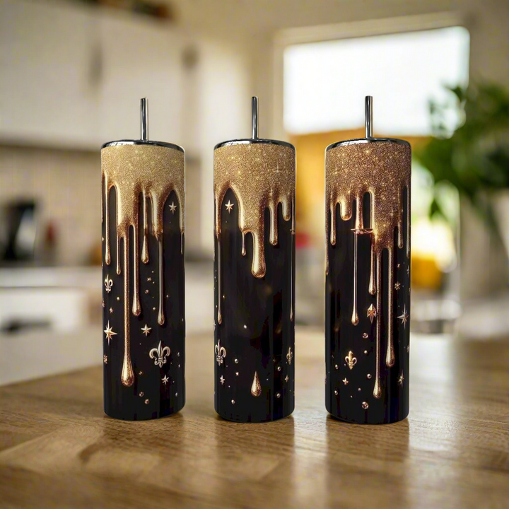 Three Gold Drip 20oz Skinny Tumblers by Kreative Kreationz, featuring black stainless steel with gold metallic drips and chic accents, stand on a wooden surface—stylish, eco-friendly drinkware for any setting.