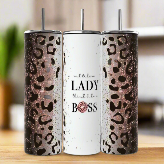 Three tall Kreative Kreationz Boss Lady 20oz Tumblers with metal straws; two have glitter leopard print, while the center features “act like a LADY think like a BOSS” in white with pink glitter on "BOSS." Stylish, eco-friendly drinkware!.
