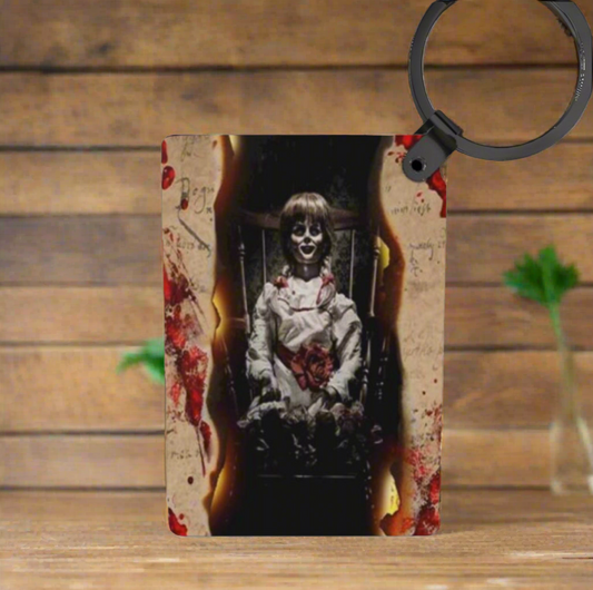 Phone case with horror-themed design featuring a doll on a wooden surface