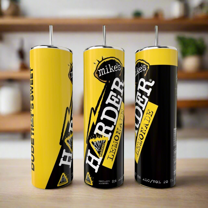 Three 20oz Mikes Harder Lemonade | Variety Tumblers by Kreative Kreationz, each with sleek metal straws, sit on a countertop with a blurred kitchen and shelves in the background.