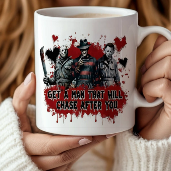A person holds the "Get a man who will chase after you" Halloween Ceramic Mug by Kreative Kreationz, featuring three horror characters with weapons, a splattered red background—perfect for spooky coffee moments.