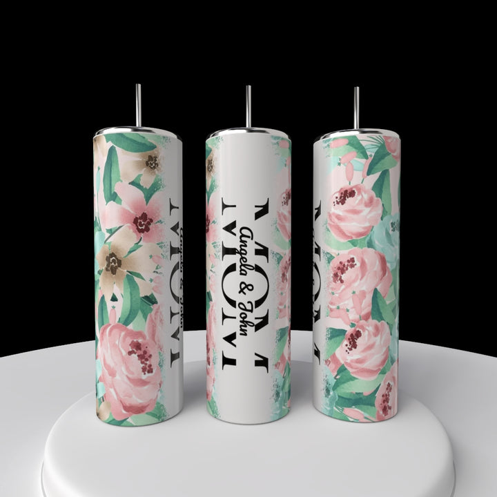 The Kreative Kreationz MOM 20oz Tumblers are tall stainless steel cups with straws, featuring a pink, green, and cream floral design. The center customizable tumbler displays "MOM" and "Angela & John" in black text on a white background.