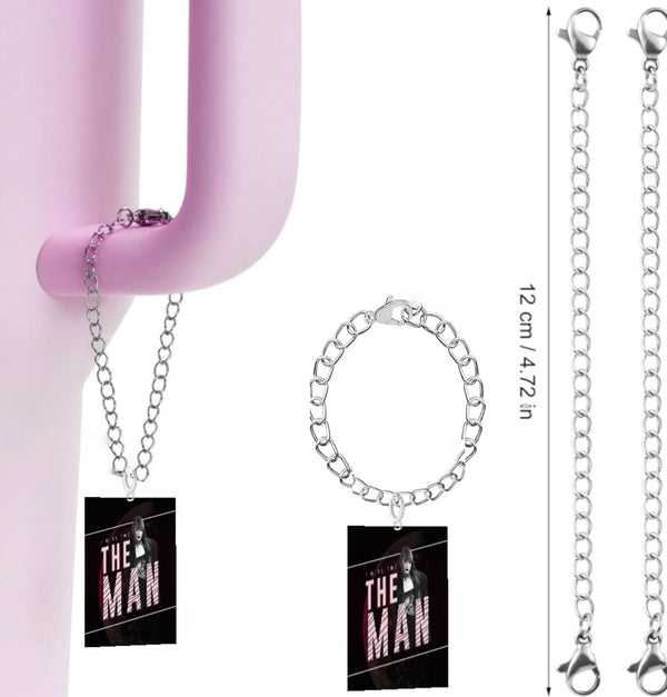 A pink hook suspends a chain with a rectangular tag inscribed "The Man" in bold red and white, featuring an image of a person. This personalized pendant from Kreative Kreationz comes in three lengths (12 cm) with lobster clasp silver chains visible at the ends.