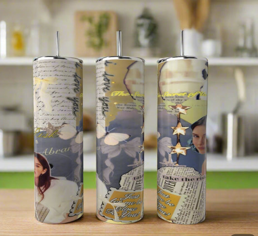 Three tall Gracie Abrams 20oz Skinny Tumblers by Kreative Kreationz, featuring blue collage-style designs with butterflies, handwritten notes, a woman’s face, gold stars, and inspirational text, stand on a kitchen counter.