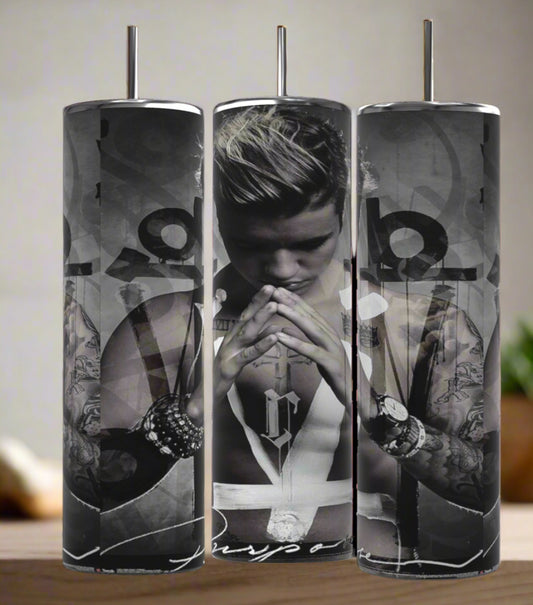 The Kreative Kreationz Justin Bieber Prayer 20oz Tumbler features a black-and-white image of him praying with "Purpose" at the bottom, abstract designs, and a spill-proof lid for convenience.