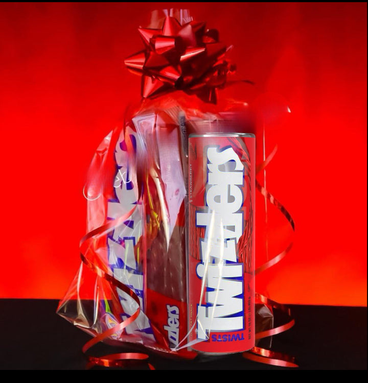 A gift-wrapped Kreative Kreationz Twizzler Tumbler/Candy Gift Set with a red bow and ribbons sits beside a sleek 20oz tumbler. The vivid red background contrasts beautifully with the tumbler's stainless steel finish, creating an eye-catching display.