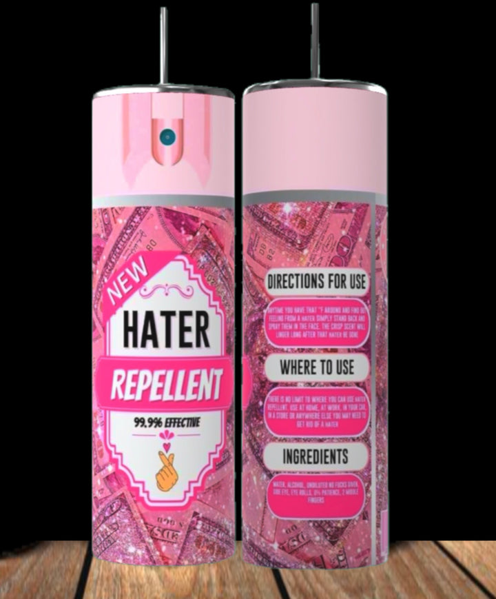 Two pink Hater Repellent 20oz Tumblers by Kreative Kreationz, featuring glitter and money graphics, stand on a wooden surface against a black background. Inspired by the playful tumbler trend, each has directions and ingredients on the back.