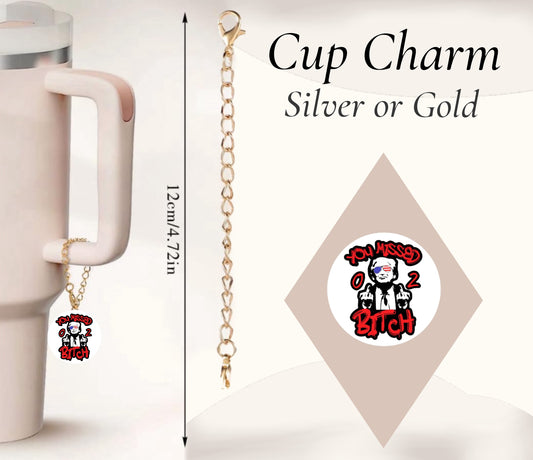 A pink 12cm cup by Kreative Kreationz features a gold chain "You Missed 0 2 Bitch" charm with an illustration, attached to the handle. The text "Cup Charm Silver or Gold" is displayed above. Named "You missed Charm Dangle," it boasts a unique handcrafted design.