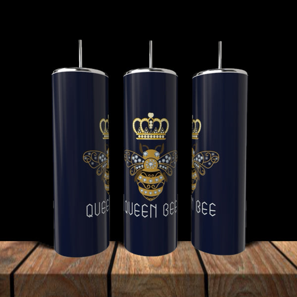 Three Kreative Kreationz Queen Bees 20oz Tumblers with silver lids and straws sit on a wooden surface, each featuring a gold crowned bee and the words “QUEEN BEE” in white on navy blue stainless steel.